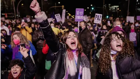 Getty Images Women raise their hands in protest