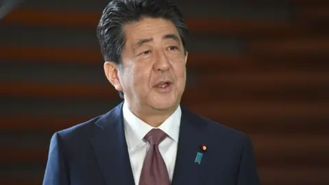 Getty Images Japan's outgoing Prime Minister Shinzo Abe speaks to the media upon his arrival at his office in Tokyo on September 16, 2020.