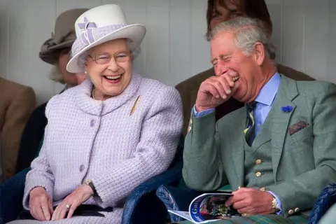 Getty Images Queen Elizabeth II and Prince Charles laugh whilst watching the children's sack race at the 2012 Braemar Highland Gathering