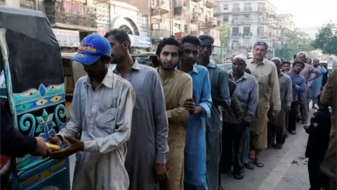 Reuters People stand in queue to receive charity food handout, during the fasting month of Ramadan, along a road in Karachi, Pakistan March 30, 2023.