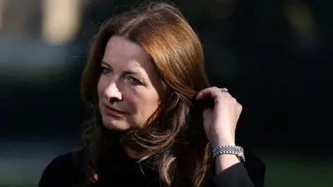 Reuters Education Secretary Gillian Keegan touches her hair during an interview