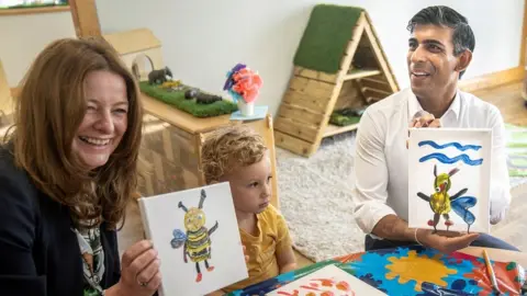 Reuters British Prime Minister Rishi Sunak and Education Secretary Gillian Keegan hold images of bees they created during a visit to the Busy Bees nursery in Harrogate