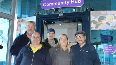 West Midlands Combined Authority Let's Chat regulars at West Bromwich Bus Station Victor Harris, David Beaver, John Walters, and Bill North with volunteer Louise Colledge.
