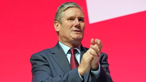 Getty Images Labour party leader, Sir Keir Starmer applauds speakers during the final day of the Labour Party conference on October 11