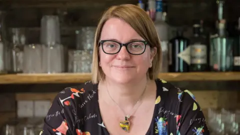 Harri Fell Harri Fell sitting in front of a bar