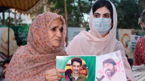 Sammi Deen Baloch  Sammi Deen Baloch (right) holds up a photograph of her father, who had been missing since 2009