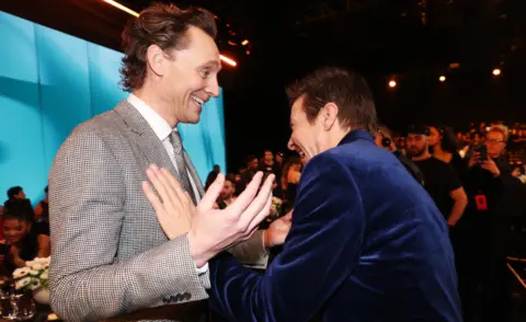 Getty Images Tom Hiddleston and Jeremy Renner attend the 2024 People's Choice Awards held at Barker Hangar on February 18, 2024 in Santa Monica, California