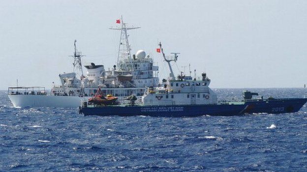 AFP This picture taken on 14 May shows a Chinese coast guard ship (back) sailing next to a Vietnamese coast guard vessel (front) near China's oil drilling rig in disputed waters in the South China Sea.