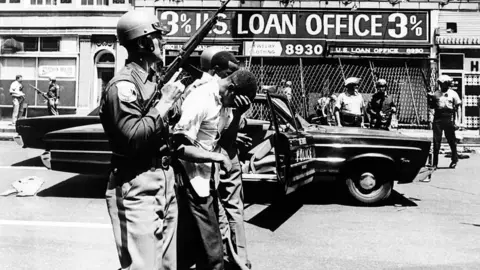 Getty Images Police officers arrest black suspects on a Detroit street on 25 July 1967.