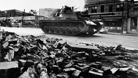 Getty Images A tank patrols a Detroit street on 25 July 1967