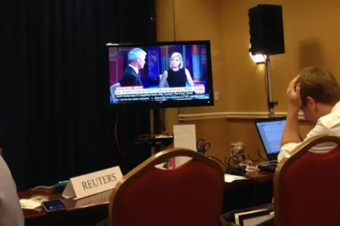 Pool reporters file their copy and watch CNN as the information is relayed to the American public