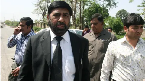 FAROOQ NAEEM Pakistani special prosecutor lawyer Chaudhry Zulfiqar Ali (2L) walks with others as he leaves Adiyala Prison in Rawalpindi on March 26, 2011, after a case hearing into the assassination of ex-premier Benazir Bhutto.