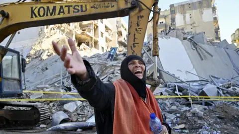 EPA A woman reacts after an Israeli air strike destroyed a multi-storey building in the southern Beirut suburb of Chiyah (21 October 2024)