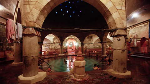 Its glittering Turkish inlaid tiles and Ottoman domes make bathing at the Rudas a truly beautiful experience (The Rudas Thermal Baths Credit: Andia/Alamy)