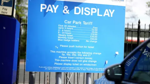 Getty Images A Pay & Display blue hospital parking tariff board with white writing for payment amount.