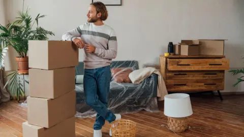 Getty Images Man with boxes in new home