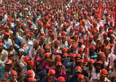 Getty Images Farmers shout slogans as they listen to speakers during a protest