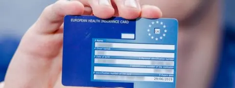 Alamy A hand holding a European Health Insurance Card