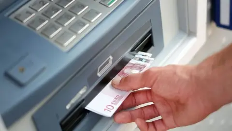 Getty Images An ATM dispensing euros