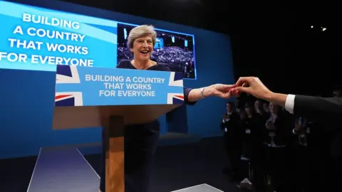 Getty Images Theresa May being handed a cough sweet at the 2017 Conservative Party Conference