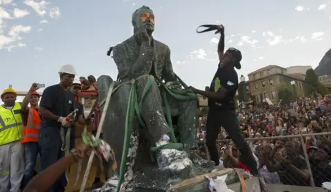 Getty Images Students attack the defaced statue of British mining magnate and politician, Cecil John Rhodes, as it is removed by a crane from its position at the University of Cape Town on April 9, 2015, in Cape Town.