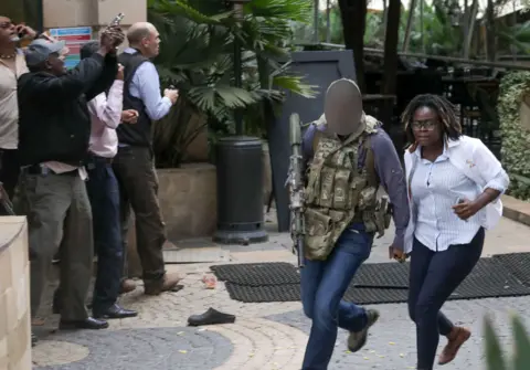 Shutterstock A man believed to be a member of the British SAS helps a woman caught up in the attack to safety