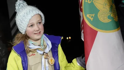 Bart Eckhardt Vaughn stood next to her scout troop's flag