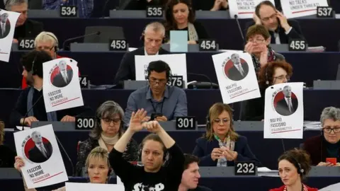 Reuters Portraits of European Parliament President Tajani with the slogan "never again fascism" are placed on the desks of a MEPs during a voting session in Strasbourg