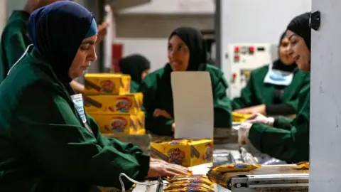 AFP Palestinian women work at a factory in the West Bank city of Ramallah (17 June 2019)
