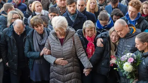 PA Media The family of Jack Merritt take part in a vigil at the Guildhall in Cambridge