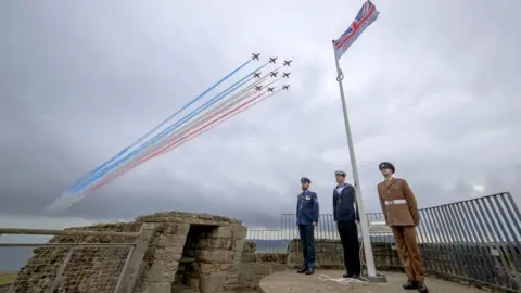 Danny Lawson/PA Wire The Red Arrows pass over an Armed Forces Day flag in the castle grounds