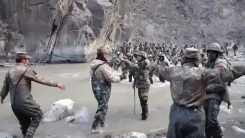 Getty Images This video frame grab taken from footage recorded in mid-June 2020 and released by China Central Television (CCTV) on February 20, 2021 shows Chinese (foreground) and Indian soldiers (R, background) during an incident where troops from both countries clashed