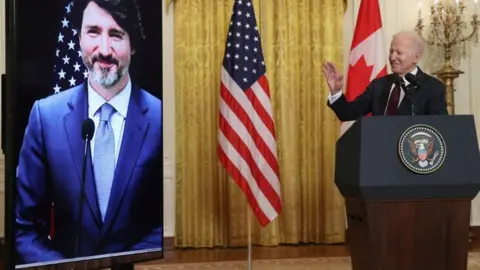 Reuters Justin Trudeau on screen and Joe Biden