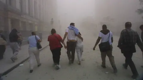 Getty Images Civilians flee as a tower of the World Trade Center collapses September 11, 2001