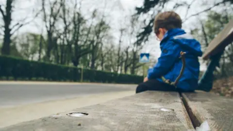 Getty Images A photo of a child on a bench