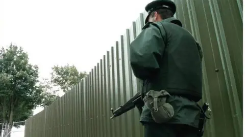 PA Media A police officer at the city walls in Derry