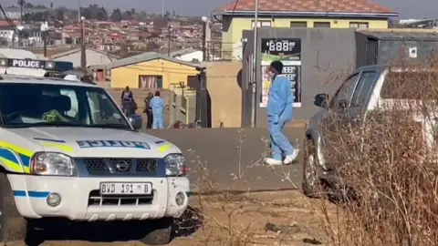AFP A police car parked in front of the bar where the shooting took place in Soweto