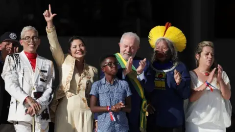Reuters Brazil's President Luiz Inacio Lula da Silva (middle) gclaps his hands after receiving the presidential sash at the Planalto Palace, in Brasilia, Brazil