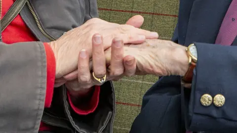 PA Media Hands being held