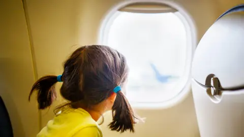 Getty Images Child looking out of an aircraft window