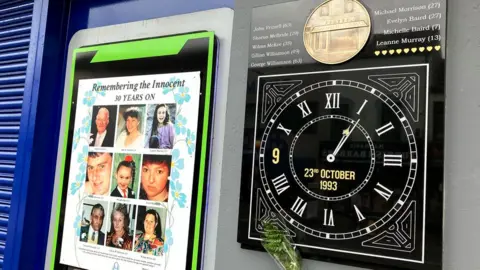 BBC The Shankill bomb memorial consisting of a clock with its hands stopped at the time of the explosion and a plaque featuring images of the victims