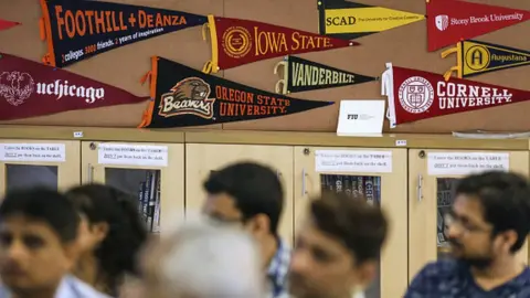 Getty Images Banners of U.S. universities are displayed in a classroom as participants attend a counselling session given by the University of Southern California (USC) at the United States-India Education Foundation