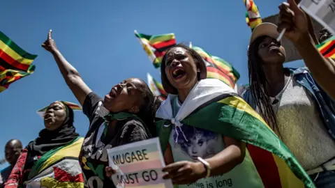 AFP This file photo taken on November 18, 2017 shows supporters of Tajamuka Sesijikisile SA, The African Democrats Opposition Party, the Zimbabwe Communist Party, the Zimbabwe Diaspora Coalition and other groups attending a rally at the Union Buildings in Pretoria, South Africa, to call for the resignation of Zimbabwe"s President.