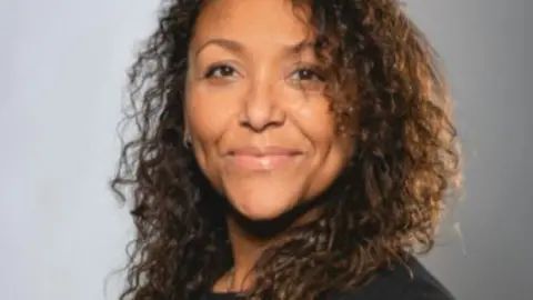 Hull College A headshot of Lynette Leith. She has long curly dark hair and is looking towards the camera, smiling.