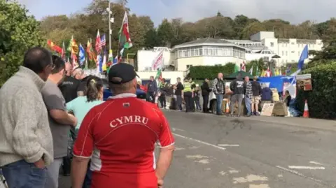 BBC Protesters gather outside the Stradey Park Hotel in Llanelli when plans to use it for temporary housing for asylum seekers was announced.
