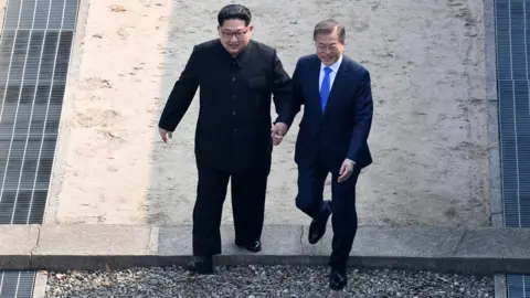 Getty Images North Korean leader Kim Jong Un (L) takes hand of South Korean President Moon Jae-in (R) as they cross the military demarcation line to the north side upon meeting with for the Inter-Korean Summit April 27, 2018 in Panmunjom, South Korea
