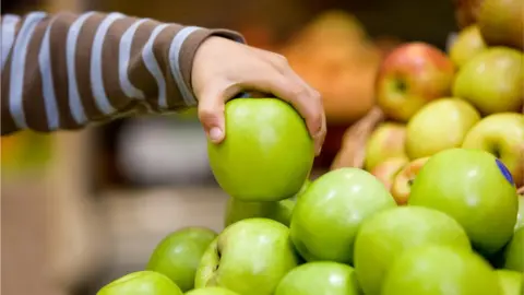 Getty Images Child lifts an apple