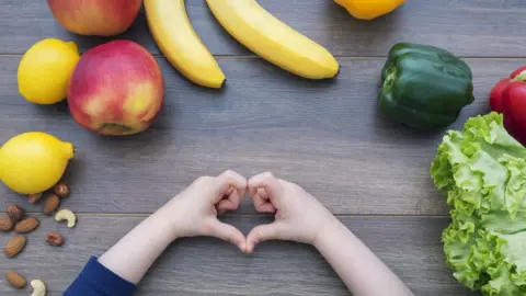 Getty Images Child with fruit sitting on table