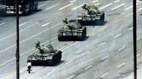 Reuters Famous Tank Man image shows a lone man with shopping bags standing in front of a row of tanks