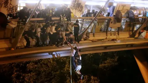 Reuters Protesters trapped inside Hong Kong Polytechnic University abseil onto a main road